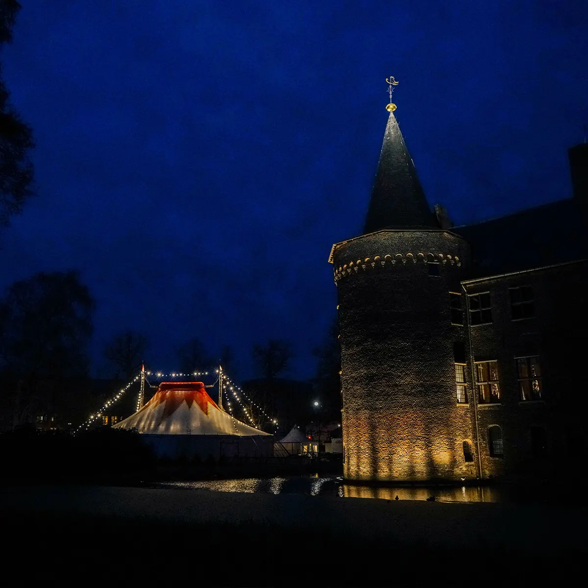 De verlichte circustent in de Kasteeltuin naast het kasteel van Helmond bij avond