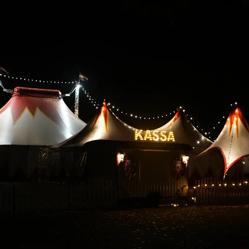 De verlichte tenten en de kassa van het Sinterklaascircus bij avond